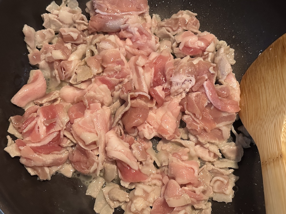 炒めている豚バラ肉