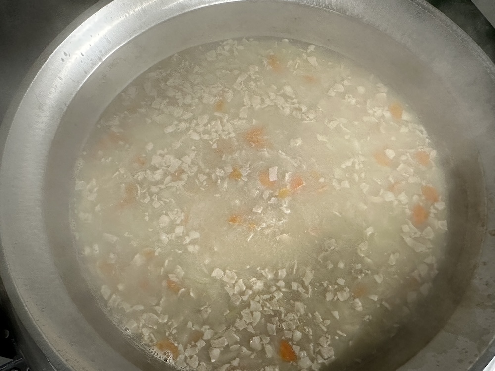 出汁で煮ている豚肉と人参、玉ねぎ